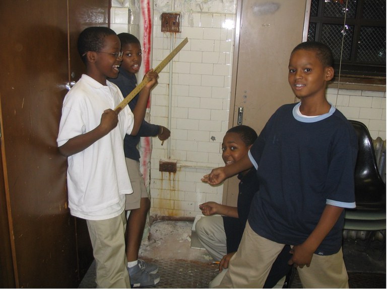 Four young school children examining a health hazard in a classroom